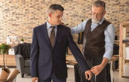 Mature tailor taking client's measurements in atelier